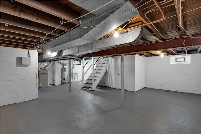 below grade area featuring a sink, water heater, stairway, electric panel, and heating unit