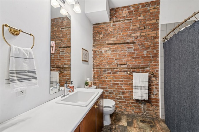 bathroom featuring visible vents, a shower with shower curtain, toilet, vanity, and brick wall