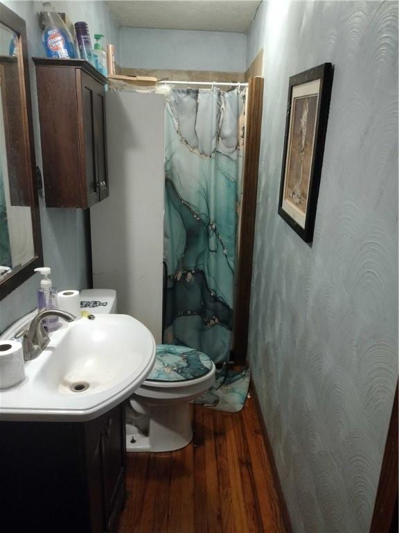 bathroom featuring vanity, curtained shower, wood finished floors, and toilet