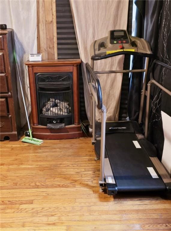 workout area with a fireplace and hardwood / wood-style flooring