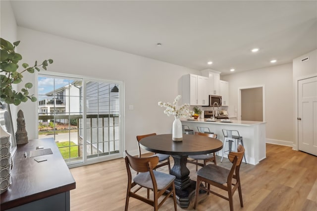 dining space with light wood-type flooring, plenty of natural light, baseboards, and recessed lighting