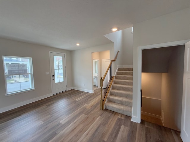 foyer featuring stairs, baseboards, wood finished floors, and recessed lighting