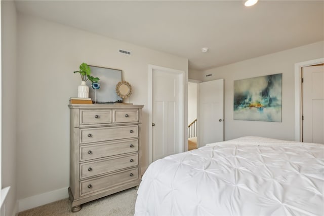 bedroom featuring visible vents, light carpet, and baseboards