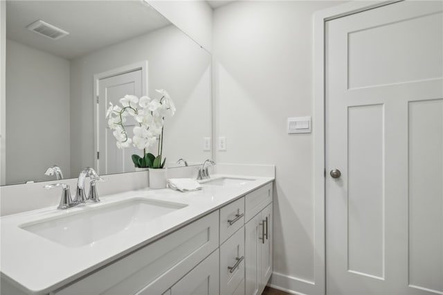 full bathroom with double vanity, a sink, visible vents, and baseboards