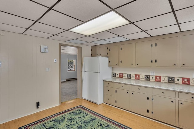 kitchen with light countertops, light wood-style flooring, a drop ceiling, and freestanding refrigerator