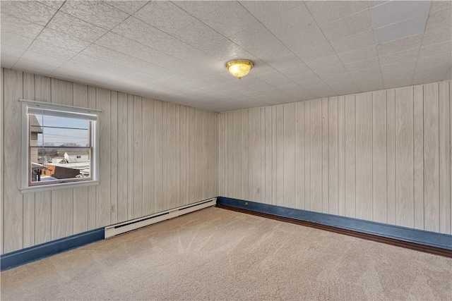 empty room featuring a baseboard heating unit and carpet floors