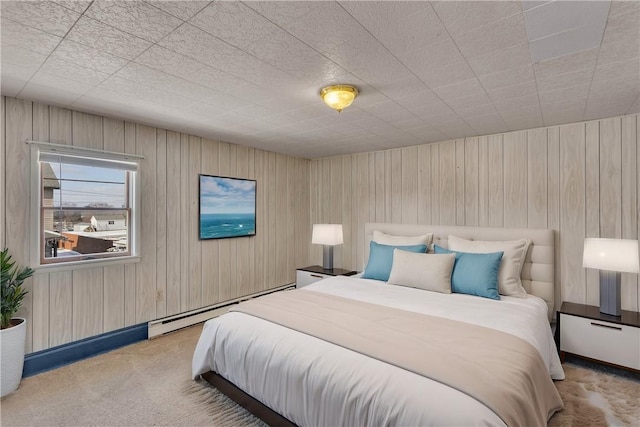 carpeted bedroom with a baseboard radiator and wood walls