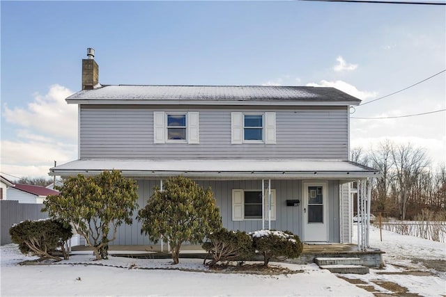 view of front of home featuring a chimney, fence, and a porch