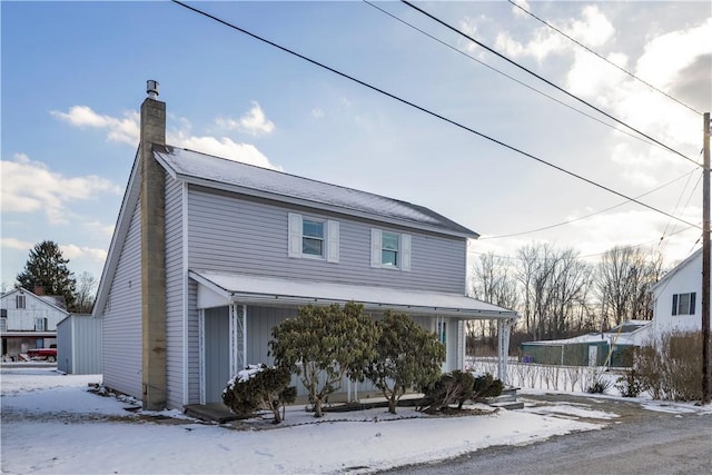 traditional home with covered porch and a chimney