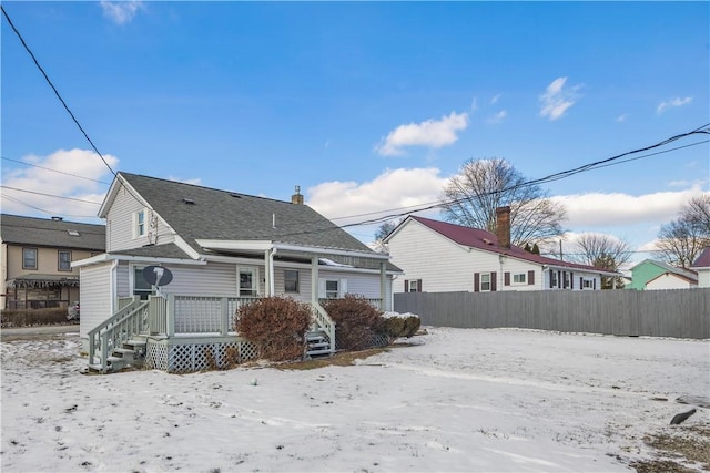 snow covered property with fence