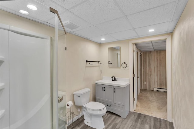 full bathroom featuring toilet, wood finished floors, vanity, baseboard heating, and walk in shower