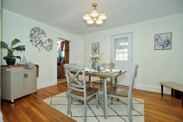 dining space featuring a notable chandelier, baseboards, and wood finished floors