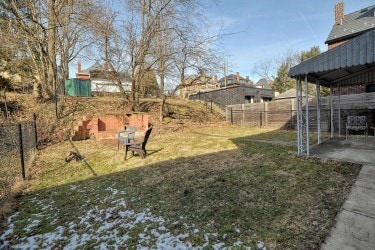 view of yard featuring driveway, fence, and a carport