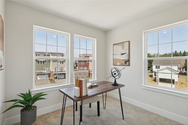 office featuring carpet, a healthy amount of sunlight, and baseboards