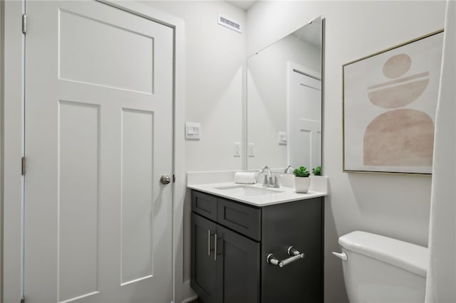 bathroom featuring visible vents, vanity, and toilet