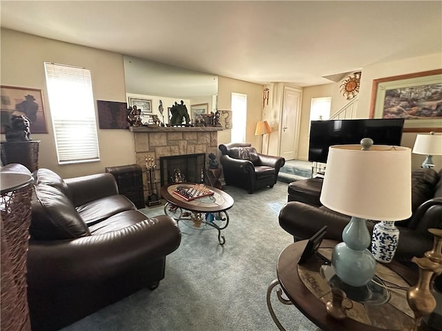 carpeted living area with a stone fireplace