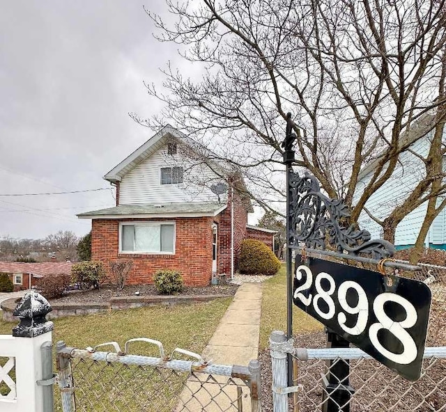 view of front of house featuring a fenced front yard, a gate, and brick siding