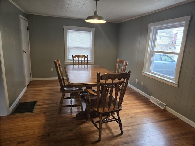 dining area with baseboards, visible vents, and wood finished floors