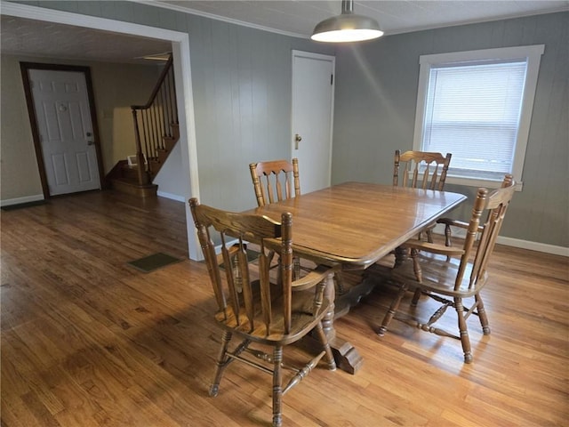 dining space with visible vents, baseboards, ornamental molding, stairs, and light wood-type flooring