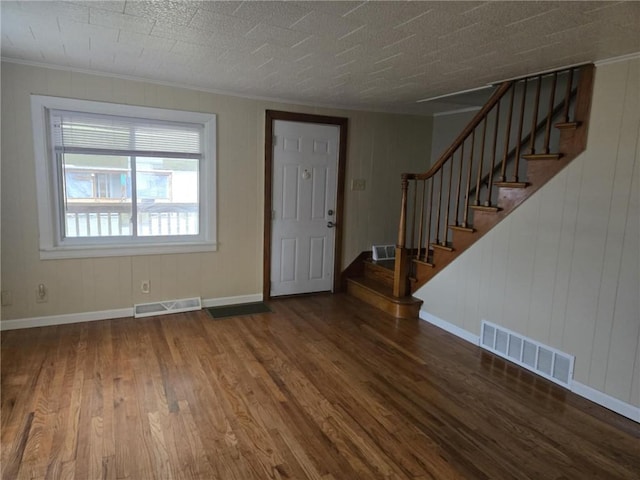 entryway with stairs, visible vents, baseboards, and wood finished floors