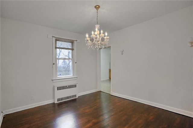 spare room with an inviting chandelier, baseboards, radiator heating unit, and wood finished floors