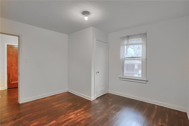 empty room featuring wood finished floors and baseboards