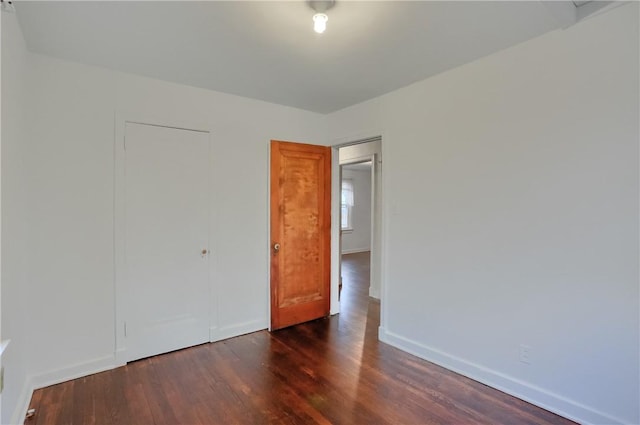 empty room with baseboards and wood finished floors