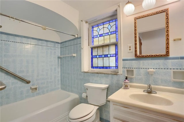 bathroom with vanity, tile walls, toilet, and shower / bathtub combination