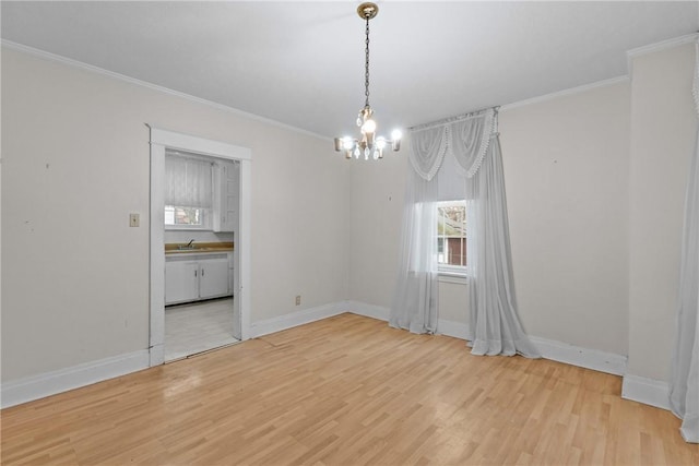 empty room featuring an inviting chandelier, crown molding, baseboards, and light wood-style floors