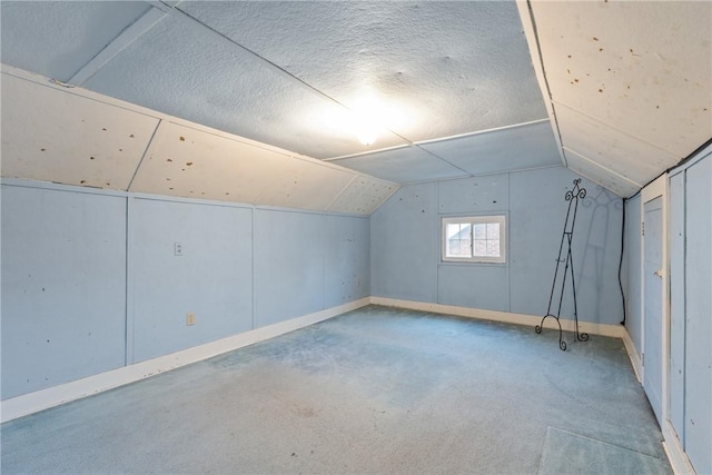 bonus room with lofted ceiling, a textured ceiling, and carpet flooring