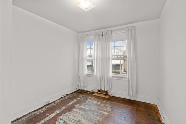 empty room featuring wood-type flooring and baseboards