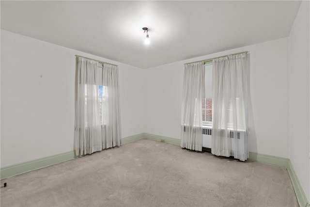 spare room featuring carpet and baseboards