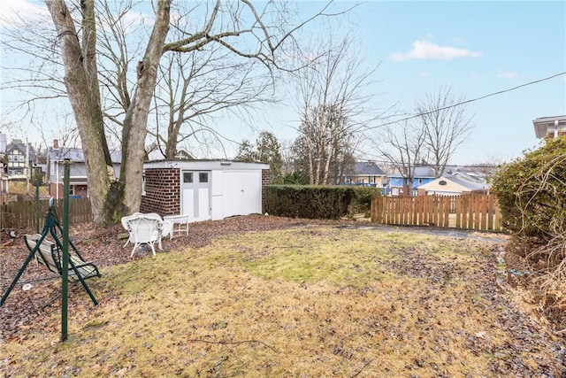 view of yard featuring fence, an outdoor structure, and a shed