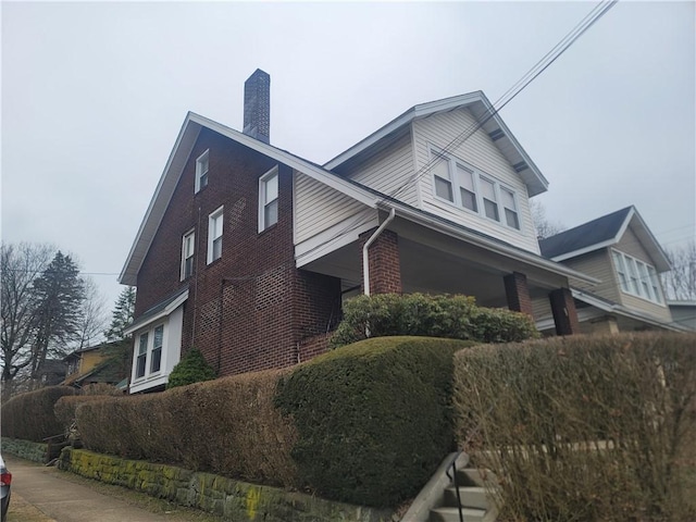 view of home's exterior featuring brick siding and a chimney