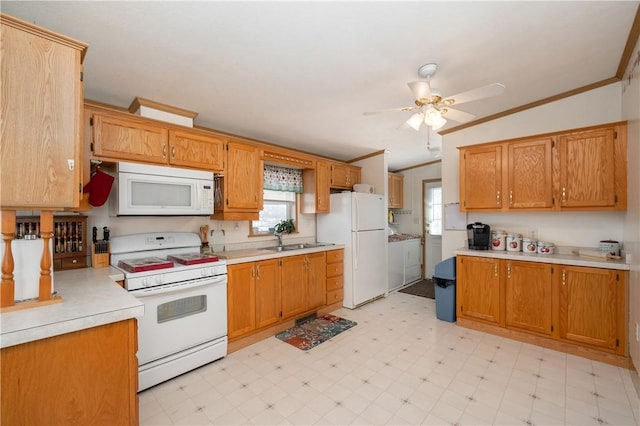 kitchen with a sink, white appliances, light countertops, and light floors