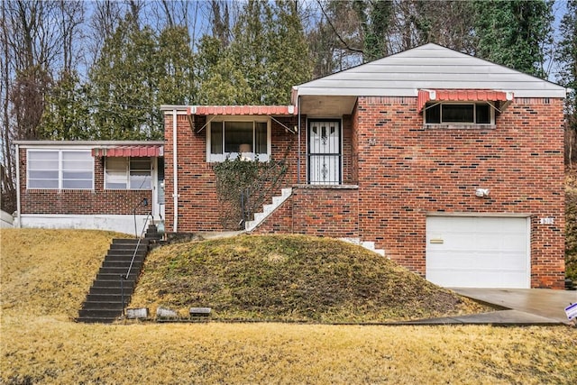 split level home featuring an attached garage, a front yard, concrete driveway, and brick siding