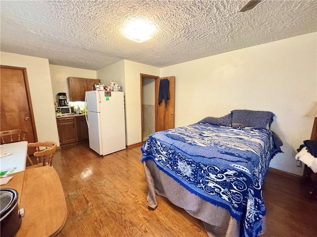 3503 State Route 208, Wilmington Twp, PA 16142 - bedroom featuring freestanding refrigerator, light wood-type flooring, and a textured ceiling