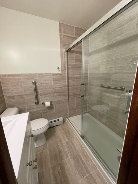 3503 State Route 208, Wilmington Twp, PA 16142 - bathroom with tile walls, baseboard heating, vanity, a stall shower, and a wainscoted wall