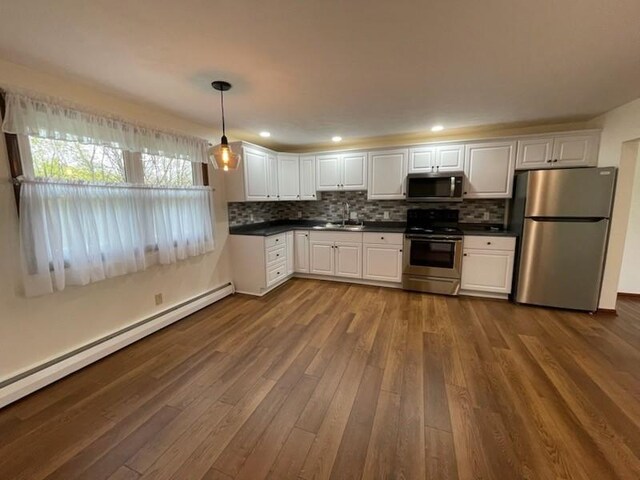 3503 State Route 208, Wilmington Twp, PA 16142 - kitchen with stainless steel appliances, a baseboard heating unit, dark countertops, dark wood-type flooring, and white cabinets