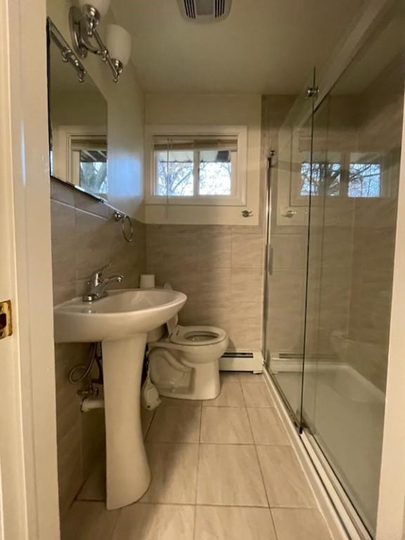 3503 State Route 208, Wilmington Twp, PA 16142 - full bath with tile walls, a baseboard radiator, tile patterned floors, and a shower stall