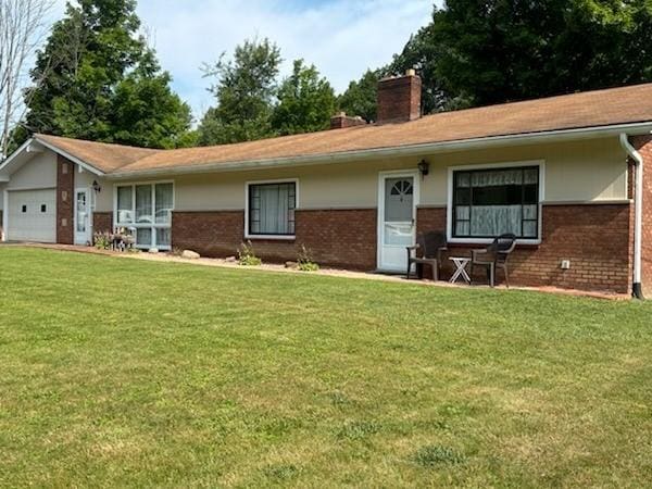 ranch-style home with a front yard, brick siding, a chimney, and an attached garage