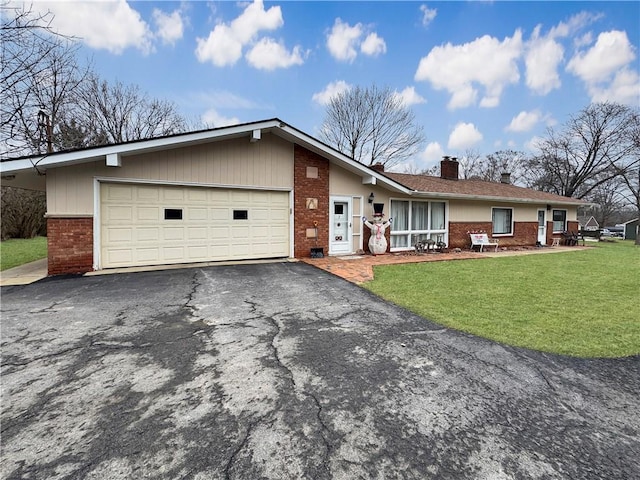 single story home with driveway, brick siding, a chimney, an attached garage, and a front yard