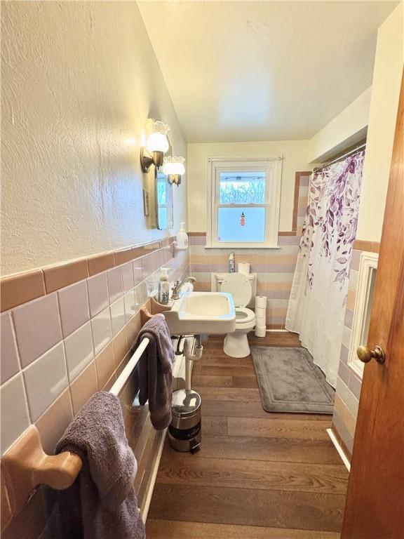 3503 State Route 208, Wilmington Twp, PA 16142 - full bath with tile walls, a wainscoted wall, wood finished floors, a shower with curtain, and vaulted ceiling