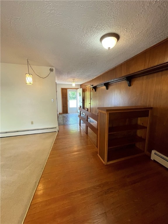 3503 State Route 208, Wilmington Twp, PA 16142 - corridor featuring a baseboard radiator, wood finished floors, a textured ceiling, and wooden walls