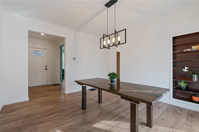 dining area with an inviting chandelier, baseboards, and wood finished floors