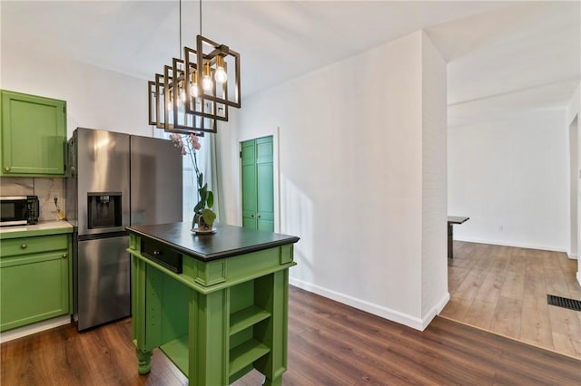 kitchen featuring green cabinetry, dark wood-style flooring, stainless steel refrigerator with ice dispenser, decorative backsplash, and an inviting chandelier