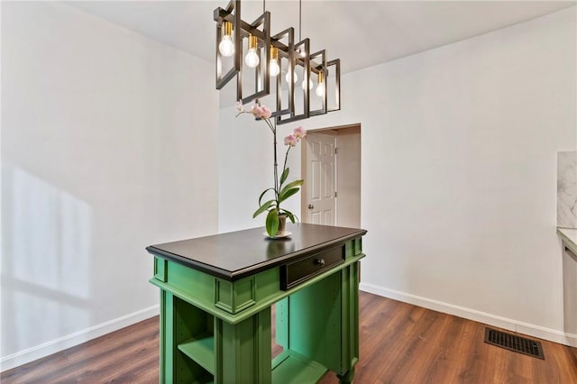 interior space featuring dark wood-style flooring, visible vents, and baseboards