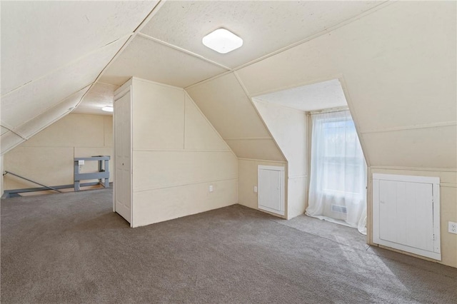 additional living space featuring lofted ceiling and carpet flooring