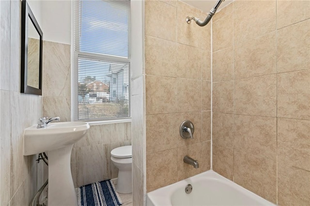 bathroom with  shower combination, a sink, tile walls, and toilet