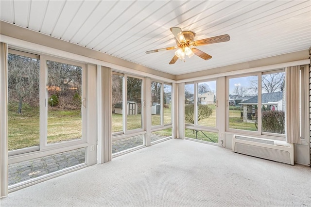 unfurnished sunroom with a wall unit AC and a ceiling fan